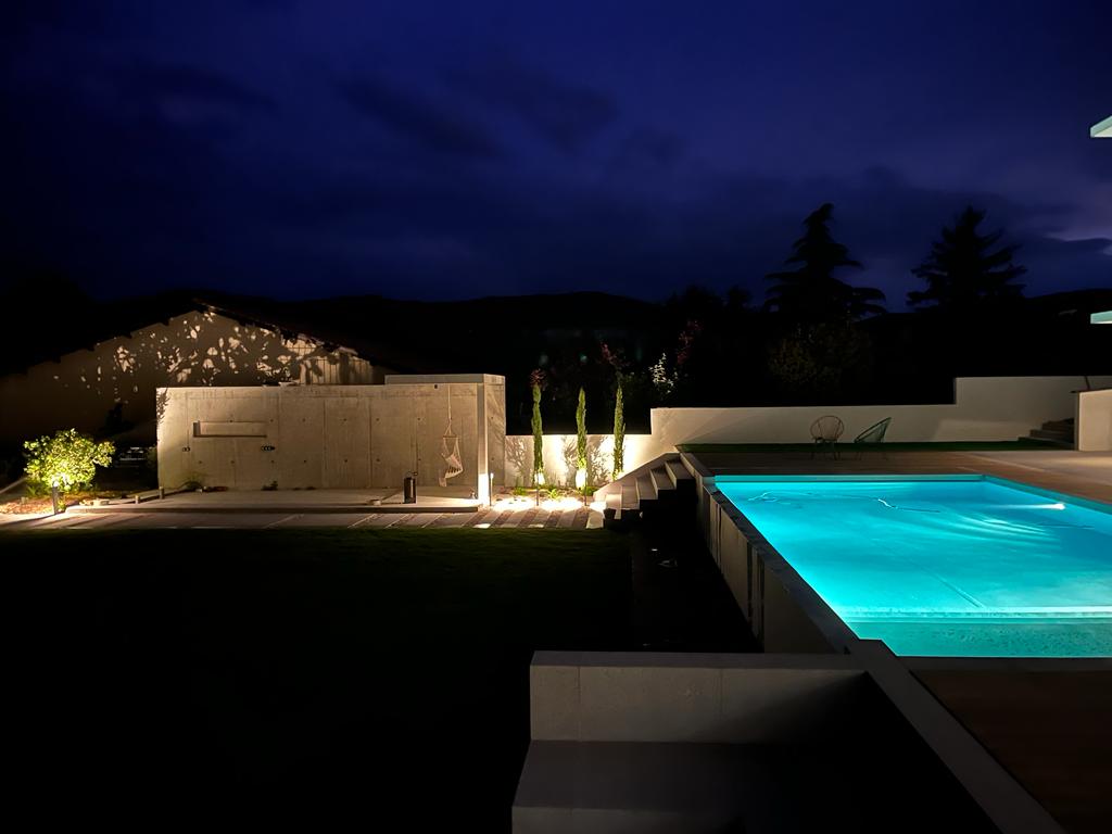 Jardin et bord de piscine éclairés de nuit dans les Monts-d'Or.