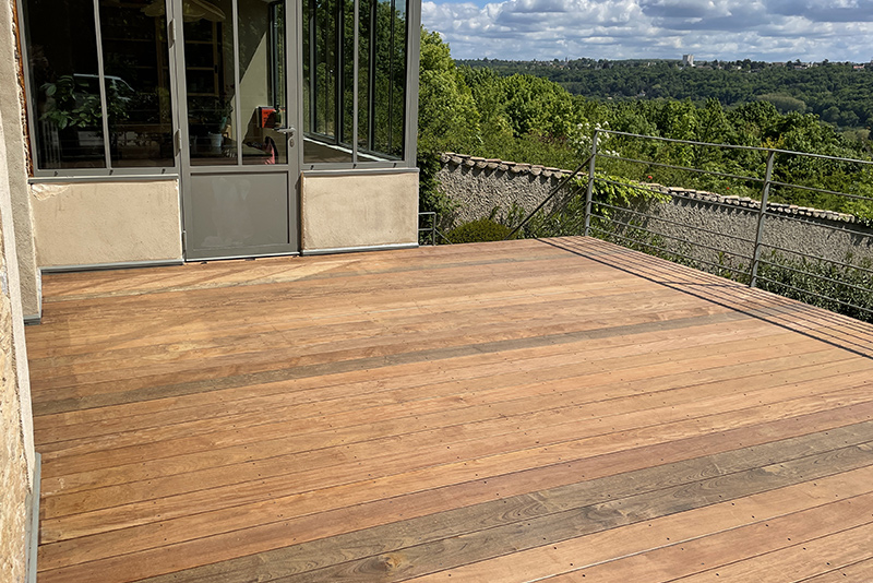 Terrasse en bois et barrière métallique, avec vue.