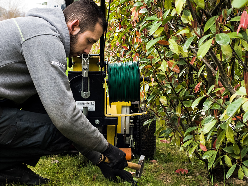 Paysagiste installant des bornes pour robot tondeuse dans le Rhône